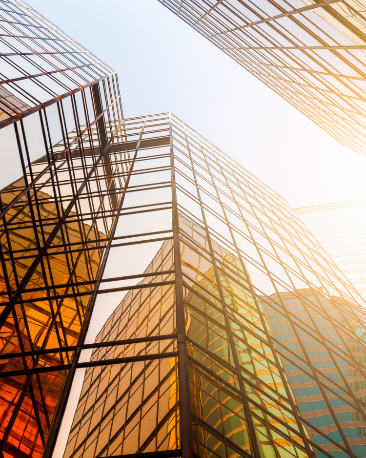 Décret tertiaire – Immeubles de bureaux et performance énergétique Façades d’immeubles tertiaires vitrés reflétant la lumière du soleil, symbolisant la mise en conformité au décret tertiaire
