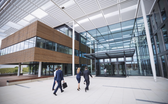 Entrée d’un bâtiment tertiaire moderne avec des professionnels